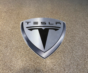 Tesla logo application on a residential garage flake floor