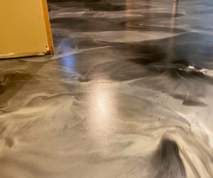 Mattefied black, white, and gray metallic floor in a residential basement