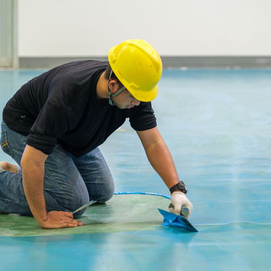 worker laying epoxy flooring