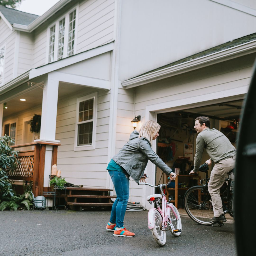 family riding bikes in driveway