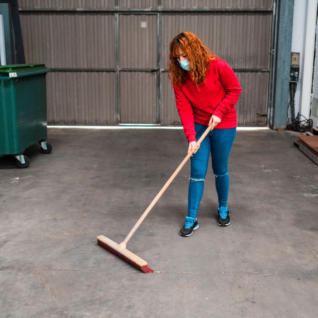 woman sweeping garage