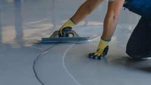 worker smoothing out epoxy flooring